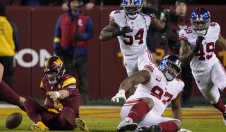 Washington Commanders quarterback Taylor Heinicke (4) fumbles the ball against the New York Giants during the second half of an NFL football game, Sunday, Dec. 18, 2022, in Landover, Md. (AP Photo/Susan Walsh)