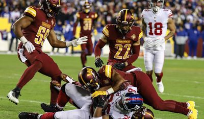 Washington Commanders Cornerback Bobby McCain with the tackle of Giants&#x27; Running Back Saquon Barkley (#26) at the Washington Commanders vs New York Giants rematch game in Landover, MD at Fedex Field on December 18th 2022 (Photo: Alyssa Howell)