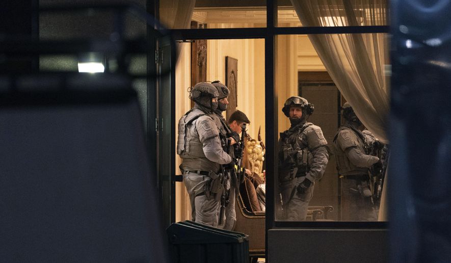 York Regional Police tactical officers stand in the lobby of a condominium building in Vaughan, Ontario, Sunday, Dec. 18, 2022. Police said multiple people are dead, including the suspect, after a shooting in a unit of the building.  (Arlyn McAdorey/The Canadian Press via AP)