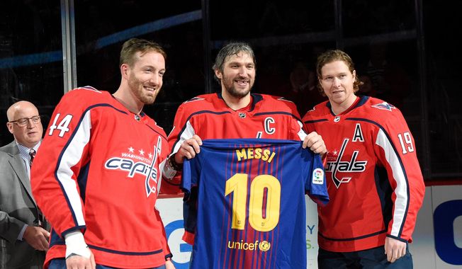 Washington Capitals left wing Alex Ovechkin, center, of Russia, poses with a Messi soccer jersey with Nicklas Backstrom (19), of Sweden, and Brooks Orpik (44) during a ceremony in honor of his 1,000th NHL hockey game, before the team&#x27;s game against the Nashville Predators on Thursday, April 5, 2018, in Washington. The happiest professional athlete outside soccer about Lionel Messi winning the World Cup might be hockey star Alex Ovechkin.  (AP Photo/Nick Wass, File) **FILE**