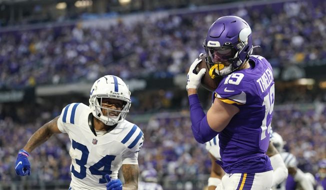 Minnesota Vikings wide receiver Adam Thielen (19) catches a 1-yard touchdown pass ahead of Indianapolis Colts cornerback Isaiah Rodgers (34) during the second half of an NFL football game, Saturday, Dec. 17, 2022, in Minneapolis. (AP Photo/Abbie Parr) ** FILE **