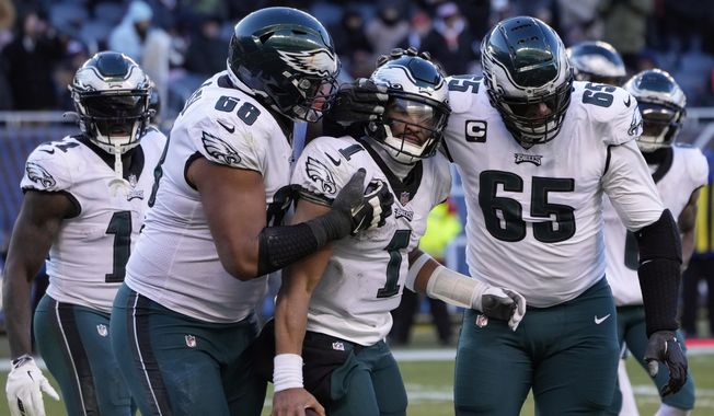 Philadelphia Eagles&#x27; Jalen Hurts (1) celebrates with Lane Johnson (65) and Jordan Mailata (68) after running for a two-point conversion during the second half of an NFL football game against the Chicago Bears, Sunday, Dec. 18, 2022, in Chicago. (AP Photo/Charles Rex Arbogast)