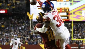 New York Giants cornerback Darnay Holmes (30) defends Washington Commanders wide receiver Curtis Samuel (10) on fourth down to seal a 20-12 victory, Sunday, Dec. 18, 2022, in Landover, Md. (AP Photo/Nick Wass)