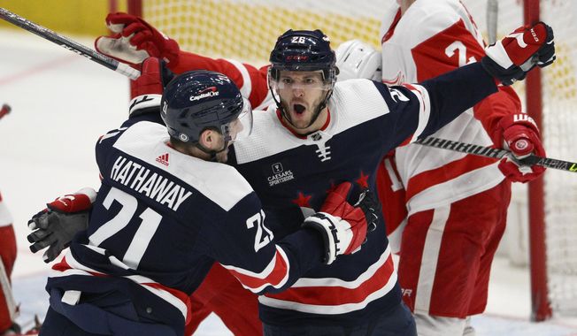 Washington Capitals center Nic Dowd (26) celebrates after his goal with right wing Garnet Hathaway (21) during the second period of an NHL hockey game against the Detroit Red Wings, Monday, Dec. 19, 2022, in Washington. (AP Photo/Nick Wass)