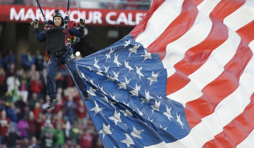 A skydiver parachutes trailing the American flag prior to the NCAA college football game between Oregon and Stanford Saturday, Nov. 14, 2015, in Stanford, Calif. (AP Photo/Ben Margot)