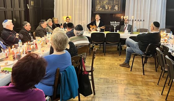 Ukrainian Jewish refugees gather in Lodz, Poland, to celebrate Hanukkah. Chief Rabbi of Poland Rabbi Michael Schudrich, with musician Dr. Yuri Vedenyapin, is one of more than 100 volunteers sent by Jewish Federations of North America to aid refugees in Europe. (Photo courtesy of JFNA)
