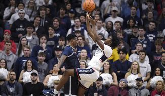 Connecticut&#39;s Tristen Newton, right, is fouled by Georgetown&#39;s Brandon Murray in the first half of an NCAA college basketball game, Tuesday, Dec. 20, 2022, in Storrs, Conn. (AP Photo/Jessica Hill)