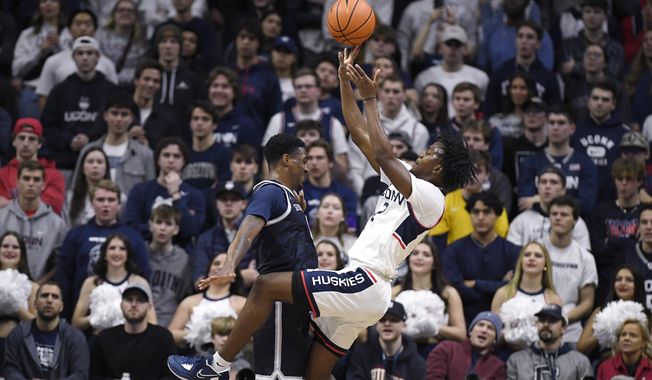 Connecticut&#x27;s Tristen Newton, right, is fouled by Georgetown&#x27;s Brandon Murray in the first half of an NCAA college basketball game, Tuesday, Dec. 20, 2022, in Storrs, Conn. (AP Photo/Jessica Hill)