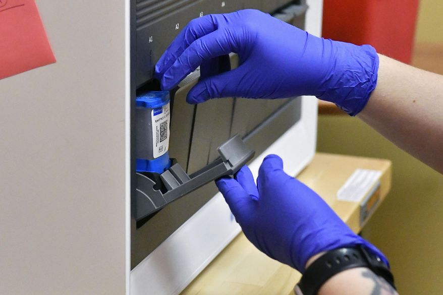 Ashley Holliday, senior medical assistant, loads a sample to test for hepatitis C and HIV in Hazard, Ky., Monday, Dec. 12, 2022. Results for both are completed within 20 minutes. A study underway in the hard-hit corner of the state is exploring a simple way to get more people treated for hepatitis C. (AP Photo/Timothy D. Easley) ** FILE **