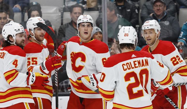Calgary Flames center Trevor Lewis, right, celebrates with teammates after scoring a goal against the San Jose Sharks during the second period of an NHL hockey game Tuesday, Dec. 20, 2022, in San Jose, Calif. (AP Photo/Josie Lepe)