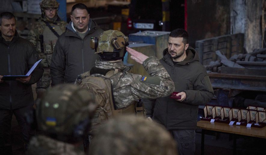 In this photo provided by the Ukrainian Presidential Press Office, Ukrainian President Volodymyr Zelenskyy, right, awards a serviceman at the site of the heaviest battles with the Russian invaders in Bakhmut, Ukraine, Tuesday, Dec. 20, 2022. (Ukrainian Presidential Press Office via AP)