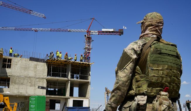 A Russian soldier guards the site of a new apartment building that is being built with the support of the Russian Defense Ministry, in Mariupol, in territory under the control of the government of the Donetsk People&#x27;s Republic, in eastern Ukraine, Wednesday, July 13, 2022. This photo was taken during a trip organized by the Russian Ministry of Defense. (AP Photo/File)