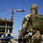 A Russian soldier guards the site of a new apartment building that is being built with the support of the Russian Defense Ministry, in Mariupol, in territory under the control of the government of the Donetsk People&#x27;s Republic, in eastern Ukraine, Wednesday, July 13, 2022. This photo was taken during a trip organized by the Russian Ministry of Defense. (AP Photo/File)