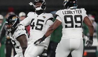 Jacksonville Jaguars linebacker K&#39;Lavon Chaisson (45) celebrates with defensive tackle DaVon Hamilton (52) and defensive end Jeremiah Ledbetter (99) after a sack against the New York Jets during the third quarter of an NFL football game, Thursday, Dec. 22, 2022, in East Rutherford, N.J. (AP Photo/Seth Wenig)