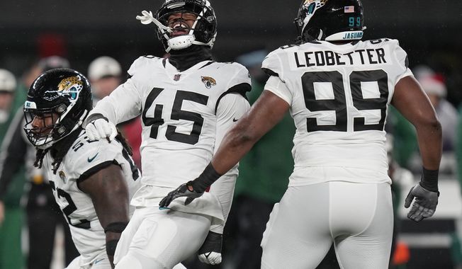Jacksonville Jaguars linebacker K&#x27;Lavon Chaisson (45) celebrates with defensive tackle DaVon Hamilton (52) and defensive end Jeremiah Ledbetter (99) after a sack against the New York Jets during the third quarter of an NFL football game, Thursday, Dec. 22, 2022, in East Rutherford, N.J. (AP Photo/Seth Wenig)