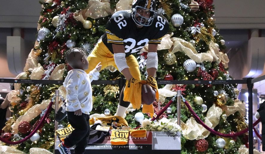 Three-year-old Steven Wooten, of Atlanta, looks at a statue depicting the &amp;quot;Immaculate Reception&amp;quot; by Pittsburgh Steelers running back Franco Harris, at Pittsburgh International Airport, Wednesday, Dec. 21, 2022, near Pittsburgh. Steven&#x27;s mother, Ryah Gadson-Wooten, was taking photos of her son with the image of Harris in the background. Harris died Wednesday at the age of 72, Harris&#x27; son, Dok, told The Associated Press. (AP Photo/Gene J. Puskar, File)