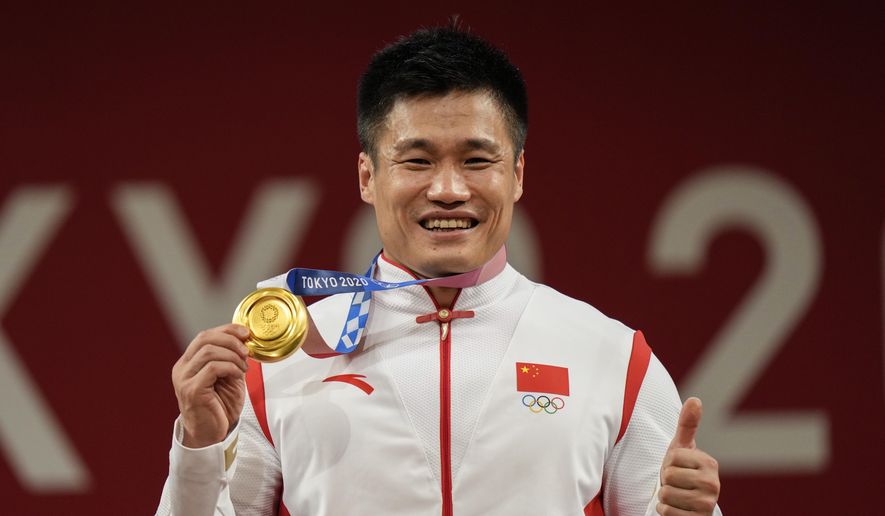 Lyu Xiaojun of China celebrates on the podium after winning the gold medal in the men&#39;s 81kg weightlifting event, at the 2020 Summer Olympics, July 31, 2021, in Tokyo, Japan. Three-time Olympic weightlifting champion Lyu Xiaojun has tested positive in a doping case. The International Testing Agency says Lyu tested positive for the endurance boosting hormone EPO on Oct. 30, 2022 while he was training. (AP Photo/Luca Bruno, file)