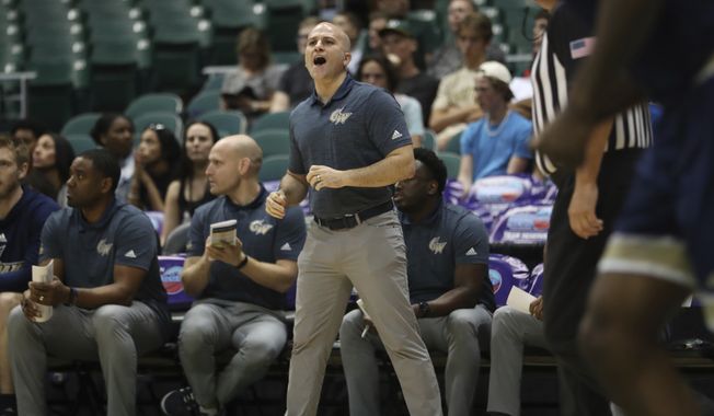 George Washington head coach Chris Caputo is seen on the sidelines as his team takes on Washington State during the first half of an NCAA college basketball game, Thursday, Dec. 22, 2022, in Honolulu. (AP Photo/Marco Garcia)  **FILE**