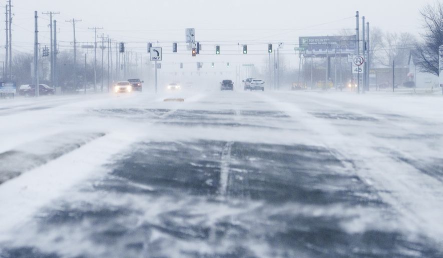 Wind blows snow Friday, Dec. 23, 2022, across U.S. 36 in Hendricks County, Ind. Winter weather is blanketing the U.S. as a massive storm sent temperatures crashing and created whiteout conditions. (Mykal McEldowney/The Indianapolis Star via AP)