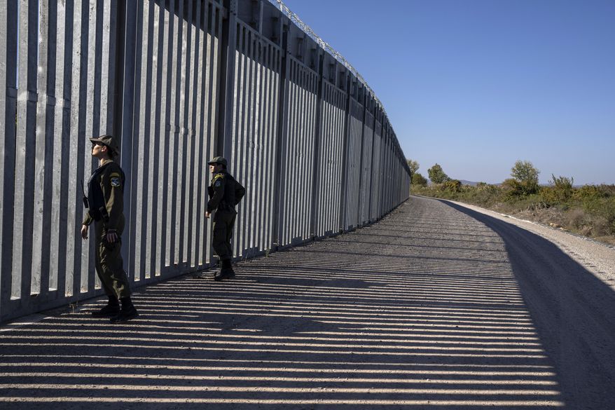 Police border guards patrol along a border wall near the town of Feres, along the Evros River which forms the the frontier between Greece and Turkey, on Sunday, Oct. 30, 2022. Greece is planning a major extension of a steel wall along its border with Turkey in 2023, a move that is being applauded by residents in the border area as well as voters more broadly. (AP Photo/Petros Giannakouris)