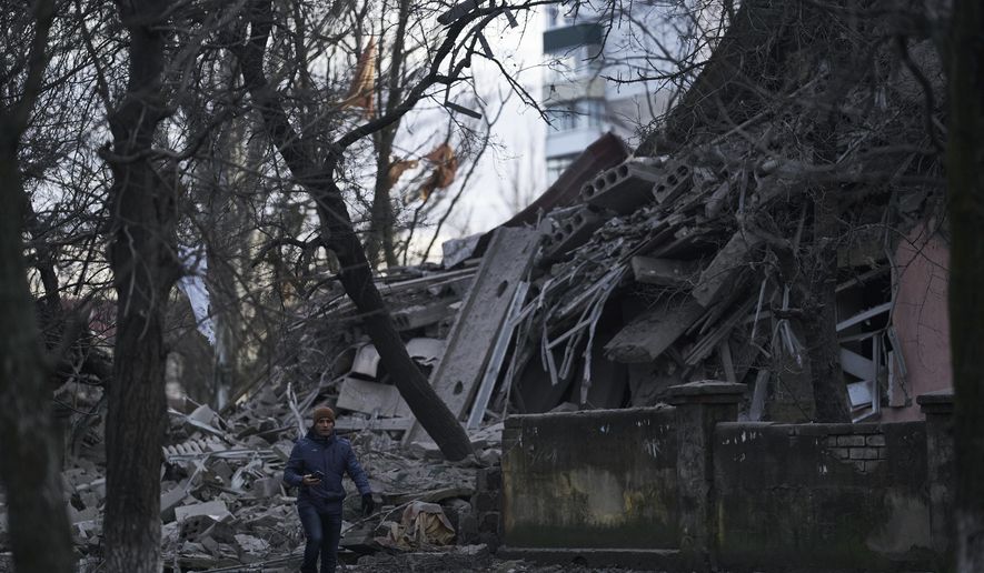 A man walks past a school building heavily damaged during a Russian attack in Kramatorsk, Donetsk region, Ukraine, Thursday, Dec. 22, 2022. (AP Photo/Libkos)