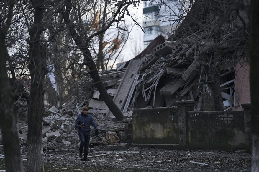 A man walks past a school building heavily damaged during a Russian attack in Kramatorsk, Donetsk region, Ukraine, Thursday, Dec. 22, 2022. (AP Photo/Libkos)