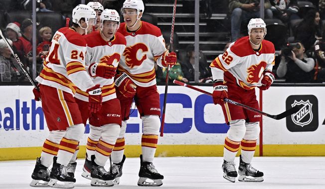 Calgary Flames defenseman Michael Stone, second from left, celebrates with teammates after scoring against the Anaheim Ducks during the first period of an NHL hockey game in Anaheim, Calif., Friday, Dec. 23, 2022. (AP Photo/Alex Gallardo)
