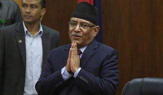 Leader of the communist party in Nepal, Pushpa Kamal Dahal, greets the gathering after announcing his resignation as prime minister, in line with an agreement made with his coalition partner party, in Kathmandu, Nepal, Wednesday, May 24, 2017. The leader of former communist rebels has become Nepal&#39;s new prime minister with the support from his ex-opponent and other smaller political parties. The announcement was made by the office of President Bidhya Devi Bhandari on Sunday after the Maoist communist party leader Pushpa Kamal Dahal met her to stake his claim for the prime minister following last month&#39;s elections. (AP Photo/Niranjan Shrestha, file)
