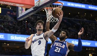 Washington Wizards forward Deni Avdija (9) goes to the basket against Philadelphia 76ers center Joel Embiid (21) during the first half of an NBA basketball game, Tuesday, Dec. 27, 2022, in Washington. (AP Photo/Nick Wass)
