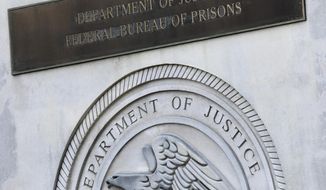 A sign for the Department of Justice Federal Bureau of Prisons is displayed in the Brooklyn borough of New York, July 6, 2020. (AP Photo/Mark Lennihan) **FILE**
