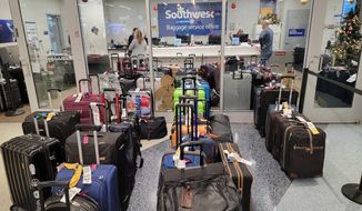 Southwest Airlines baggage service office staff assist stranded passengers with their luggage at the Southwest terminal at the Los Angeles International Airport, on Tuesday, Dec. 27, 2022. (AP Photo/Damian Dovarganes)