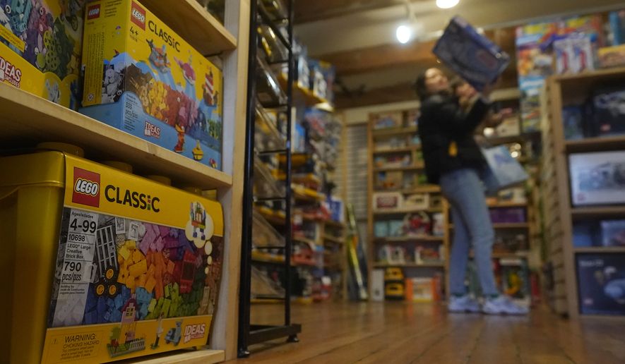 Customers shop near Lego toys at a Five Little Monkeys store in Berkeley, Calif., Monday, Dec. 12, 2022. (AP Photo/Jeff Chiu)