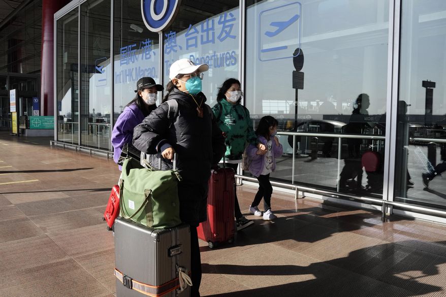 Passengers wearing masks walk through the Capital airport terminal in Beijing on Dec. 13, 2022. On Wednesday, Dec. 28, 2022, the U.S. announced new COVID-19 testing requirements for all travelers from China, joining other nations imposing restrictions because of a surge of infections. (AP Photo/Ng Han Guan, File)