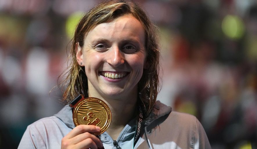 Gold medalist Katie Ledecky of the United States poses with her medal after the Women 800m Freestyle final at the 19th FINA World Championships in Budapest, Hungary, Friday, June 24, 2022. The American swimmer turned in another stellar performance at the world championships, set a pair of world records, and capped 2022 as The Associated Press Female Athlete of the Year by a panel of 40 sports writers and editors from news outlets across the country. (AP Photo/Petr David Josek, File)