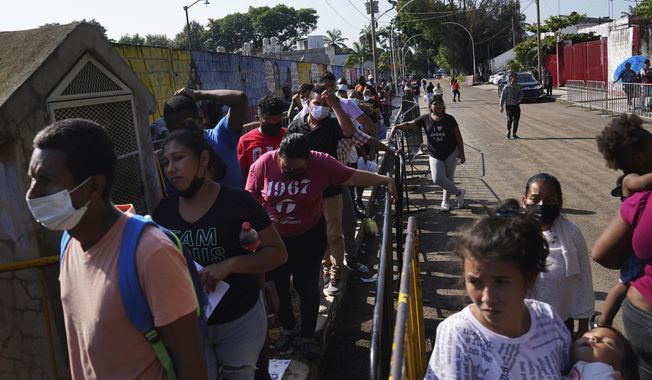Migrants wait in line for their turn to apply for legal migration documents outside the National Immigration Institute in Tapachula, Chiapas state, Mexico, Tuesday, Oct. 4, 2022. Migrants use “safe passage” permits — the common term for some of the temporary documents issued by the Mexican government. Most allow the holder to leave the country through any border, including the one with the United States. (AP Photo/Marco Ugarte) **FILE**