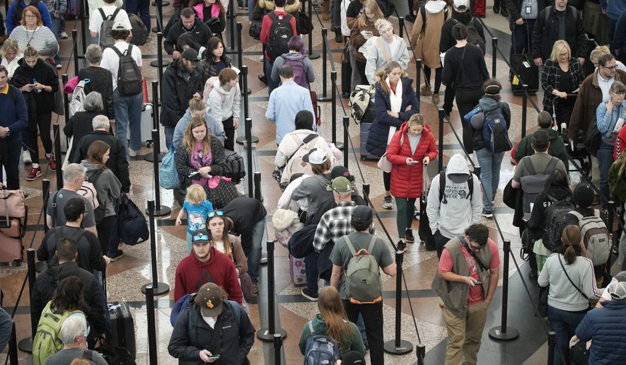 Travelers wait in line at the south security checkpoint in Denver International Airport Tuesday, Dec. 27, 2022, in Denver. (AP Photo/David Zalubowski)