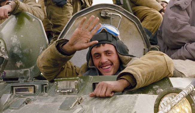 A smile and a wave from a Soviet soldier, as his armoured convoy makes its way back to the Soviet Union along a north Afghanistan highway, Feb. 7, 1989. Despite Afghanistan&#x27;s reputation as &quot;the graveyard of empires,&quot; the Soviet Union sent in troops in 1979, quickly assassinating the country&#x27;s leader and moving to install a compliant successor. More than 14,000 Soviet Army troops died in the conflict that seriously eroded the image of Soviet military superiority. (AP Photo/Boris Yurchenko, File)