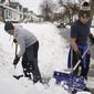 Volunteers Tim Grant of Buffalo, left, and Riley Wager of Pendleton, right, help shovel out a driveway while participating in the &quot;Snowplow Mafia&quot; volunteer snow shovel brigade in Buffalo, N.Y., on Thursday, Dec. 29, 2022. (Derek Gee/The Buffalo News via AP)