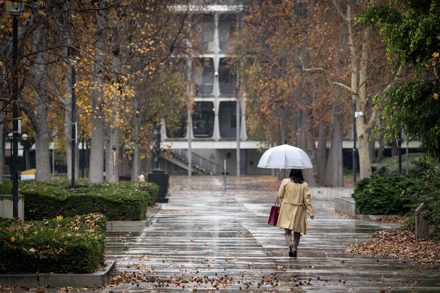 Umbrellas come out near the Van Nuys, Calif., courthouse as rain begins to fall Tuesday, Dec. 27, 2022. One-half to two inches of rain is expected in Southern California through Wednesday. (David Crane/The Orange County Register via AP)