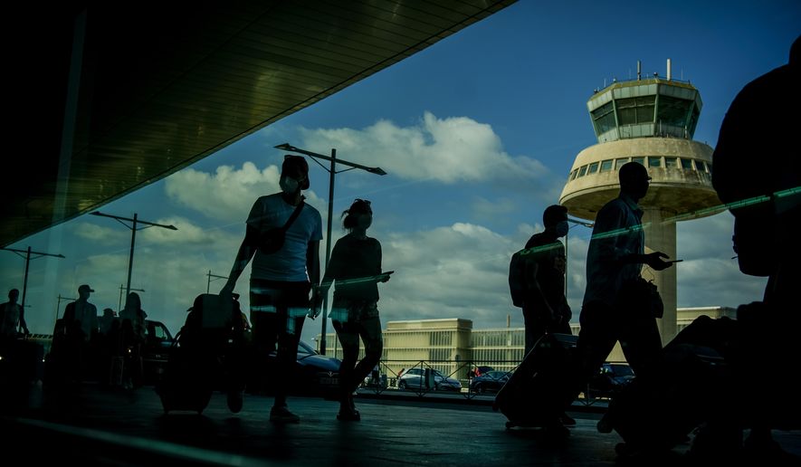 Passengers carry luggage at the Barcelona airport, Spain, on July 9, 2021. Spain is following EU neighbor Italy and other countries by requiring air passengers coming from China to have negative COVID-19 tests or proof of vaccination. Health Minister Carolina Darías said Friday Dec. 30, 2022 that Spain would be pushing for similar measures at a European level, following the surge in cases in China. (AP Photo/Joan Mateu, File)
