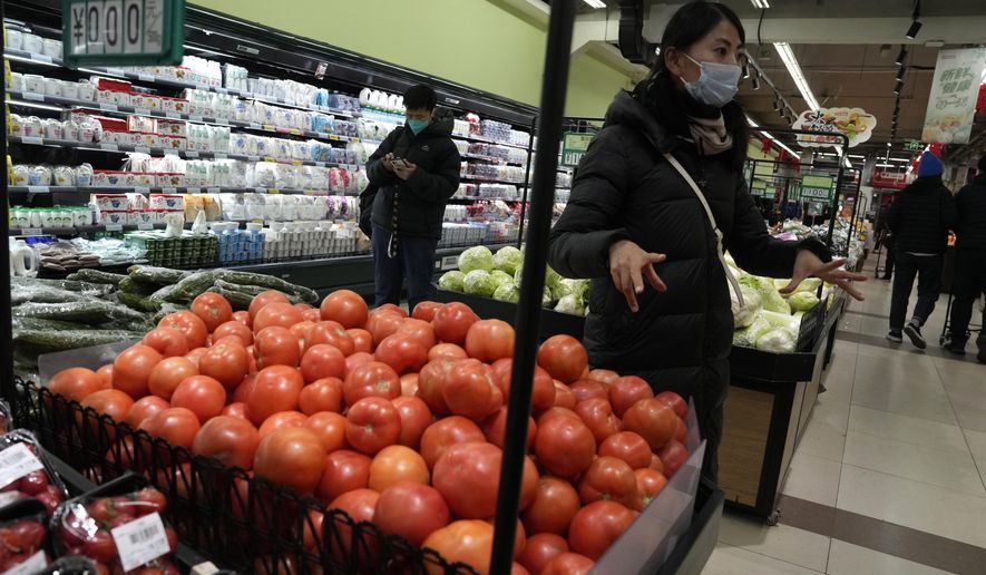 Shoppers buy fresh produces at a supermarket in Beijing, Wednesday, Dec. 28, 2022. China is on a bumpy road back to normal life as schools, shopping malls and restaurants fill up again following the abrupt end of some of the world&#x27;s most severe restrictions even as hospitals are swamped with feverish, wheezing COVID-19 patients. (AP Photo/Ng Han Guan)