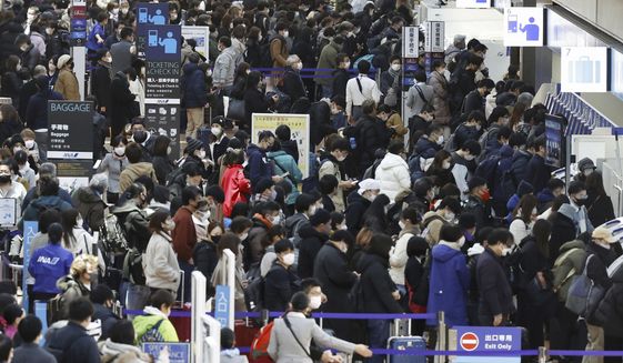 Travelers crowd at a departure lobby of Haneda airport in Tokyo Thursday, Dec. 29, 2022. Japan on Thursday reported a record 420 single-day coronavirus deaths, one day after reaching an earlier record of 425 deaths, according to the Health Ministry. (Kyodo News via AP)