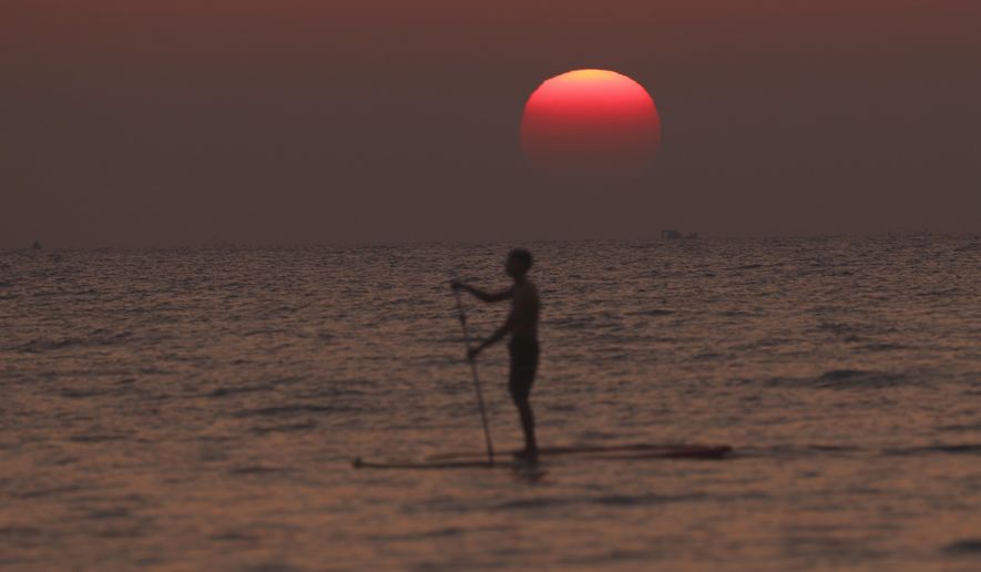 Visitor relax during sunset at Ngapali Beach, in Myanmar&#x27;s western Rakhine State, on New Year&#x27;s Eve, Saturday, Dec.31, 2022. (AP Photo/Aung Shine Oo)