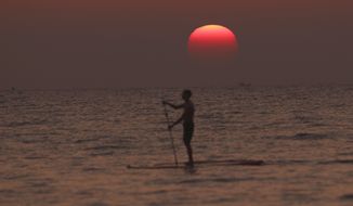 Visitor relax during sunset at Ngapali Beach, in Myanmar&#39;s western Rakhine State, on New Year&#39;s Eve, Saturday, Dec.31, 2022. (AP Photo/Aung Shine Oo)