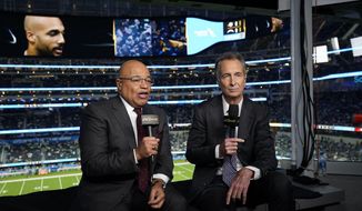 NBC Sports play-by-play announcer Mike Tirico, left, sits next to color commentator Cris Collinsworth before an NFL football game between the Los Angeles Chargers and the Miami Dolphins on Dec. 11, 2022, in Inglewood, Calif. (AP Photo/Jae C. Hong)