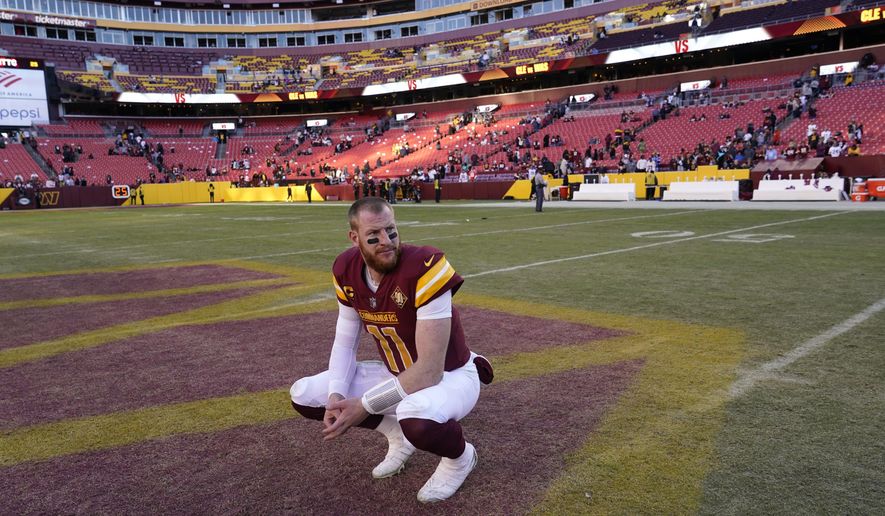 Washington Commanders quarterback Carson Wentz kneels on the field after a 24-10 loss to the Cleveland Browns, Sunday, Jan. 1, 2023, in Landover, Md. (AP Photo/Susan Walsh)