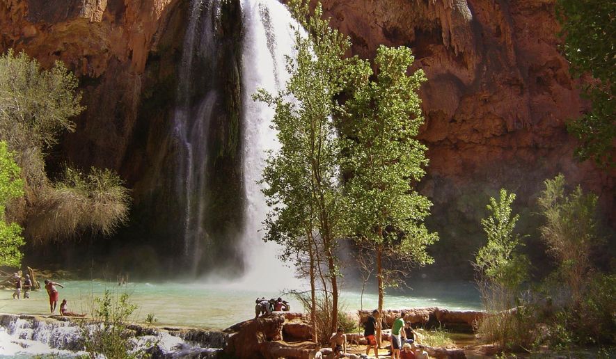 FILE - Hikers enjoy the pools below Havasu Falls, one of three main waterfalls in Havasupai Canyon in Supai, Ariz., a pocket of the Grand Canyon, on April 8, 2006. President Joe Biden has approved a disaster declaration made by the Havasupai Tribe in northern Arizona, freeing up funds for flood damage as it prepares to re-open for tourists. The Federal Emergency Management Agency confirmed Sunday, Jan. 1, 2023, that federal emergency aid will be given to supplement the tribe&#x27;s own recovery efforts from the October flooding. (John Corrigan/Los Angeles Times via AP, File)
