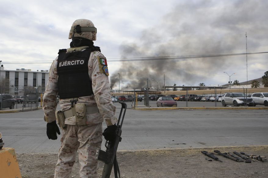 A Mexican soldiers stands guard outside a state prison in Ciudad Juarez, Mexico, Sunday Jan 1, 2023. Mexican soldiers and state police regained control of a state prison in Ciudad Juarez across the border from El Paso, Texas after violence broke out early Sunday, according to state officials. (AP Photo/Christian Chavez)