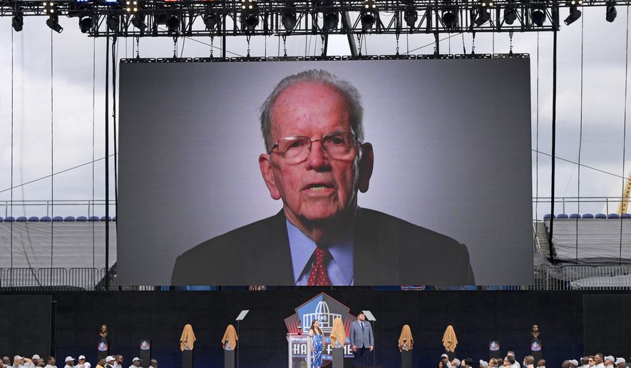 A video of NFL official Art McNally is played during an induction ceremony at the Pro Football Hall of Fame in Canton, Ohio, Saturday, Aug. 6, 2022. Art McNally, the first on-field official inducted into the Pro Football Hall of Fame, has died. He was 97. His son, Tom McNally, said Monday, Jan. 2, 2023, that his father died of natural causes at a hospital in Newtown, Pennsylvania, near his longtime home. (AP Photo/David Dermer, File)
