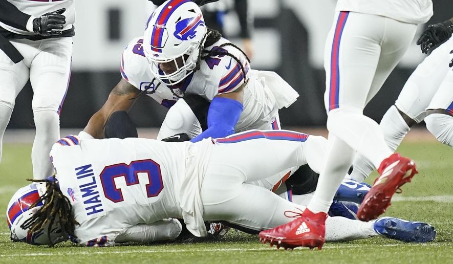 Buffalo Bills safety Damar Hamlin (3) lies on the turf after making a tackle on Cincinnati Bengals wide receiver Tee Higgins, blocked from view, as Buffalo Bills linebacker Tremaine Edmunds (49) assists at the end of the play during the first half of an NFL football game between the Cincinnati Bengals and the Buffalo Bills, Monday, Jan. 2, 2023, in Cincinnati. After getting up from the play, Hamlin collapsed and was administered CPR on the field. (AP Photo/Joshua A. Bickel)